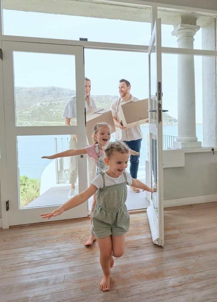 Baugrundstück an der Küste mit neu erbauter Villa und Familie beim Einzug