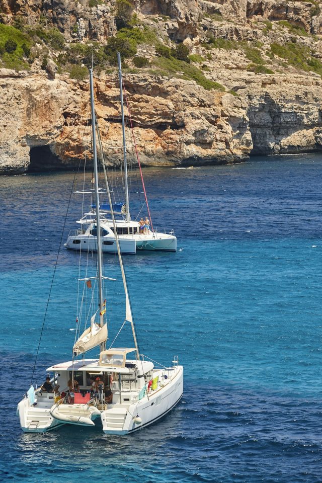 Bucht von Cala Ratjada mit türkisfarbenem Wasser und Katamaran