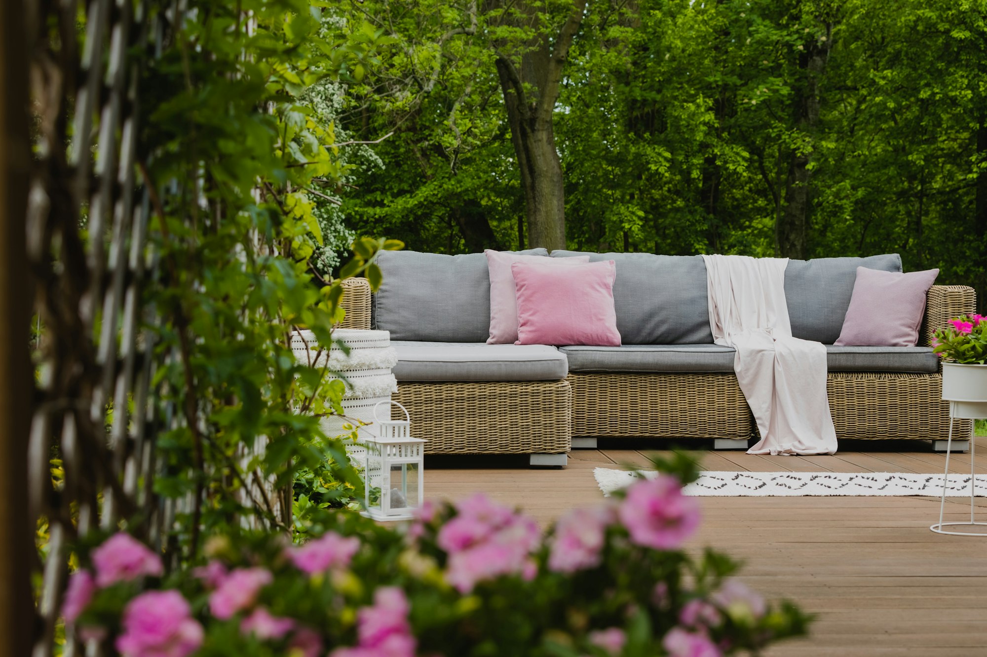 Immobilie Marratxí auf Mallorca mit bewachsenem Garten und Lounge Sofa auf der Holzterrasse
