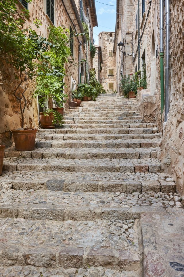 Traditionelle, mit Pflanzen dekorierte Steingasse in Pollenca auf Mallorca